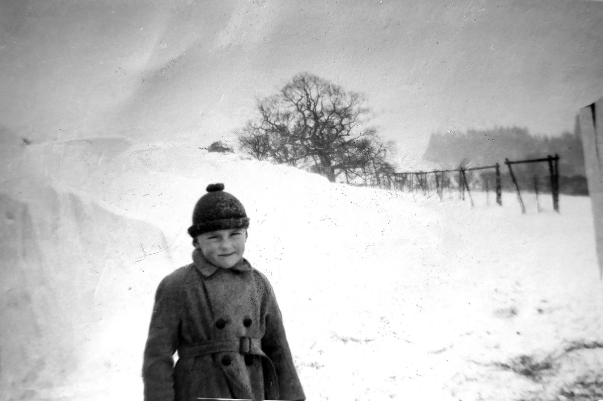 The entrance drive at Holt Ball Farm blocked by snowdrifts, with a young Philip Ashford dressed for the conditions. (Philip Ashford coll.)